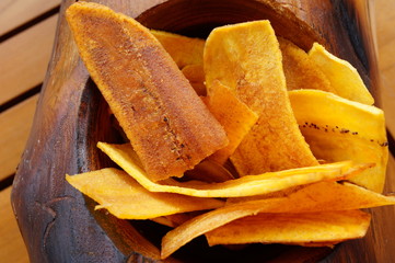 Fried plantain chips in a wooden bowl © eqroy