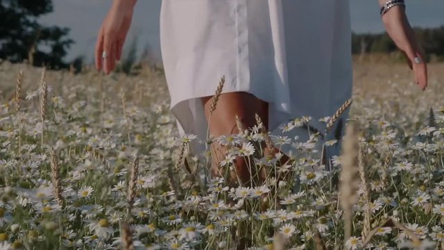 Young happy girl walking on the flower field