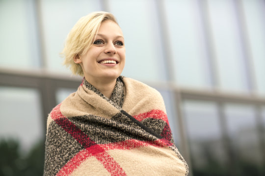 Portrait of smiling blonde woman wrapped in cloth