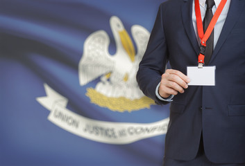 Businessman holding badge on a lanyard with USA state flag on background - Louisiana