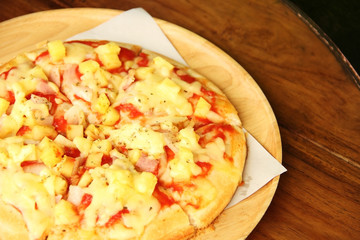 Hawaiian Pizza pineapple , ham and cheese on wooden table