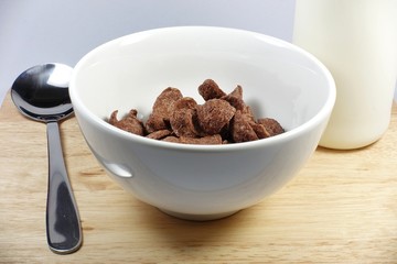 cereal in white bowl with spoon with milk