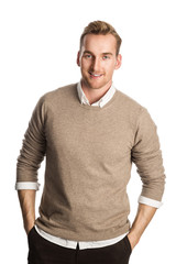 Fototapeta premium Handsome blonde man wearing a brown pullover and white shirt, standing smiling against a white background.