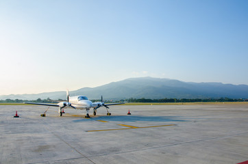 Fototapeta na wymiar Small Airplane or Aeroplane Parked at Airport.Small Airplane Famous to use Private Airplane.Sunset Light and Mountain View.