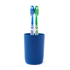 Pair of toothbrushes in blue plastic cup isolated over white background