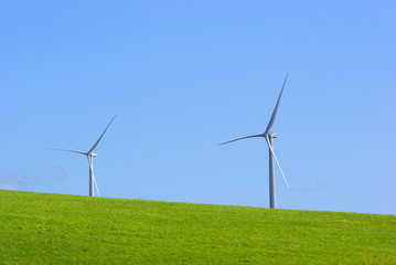 Fototapeta na wymiar 青空と緑の丘　白い風車