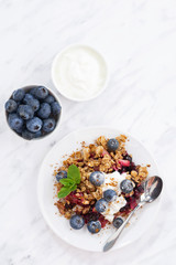 berry crumble with oat flakes on a plate, vertical, top view