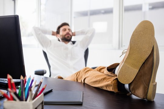 Relaxing man with his leg crossed on the desk