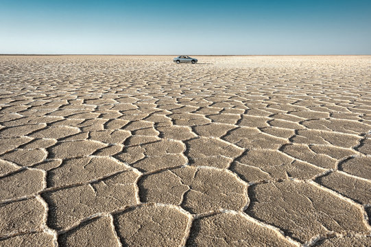 Iran, near Khur (Khor), Salt Lake: In the middle of a unique salt lake with car and horizon in the background.