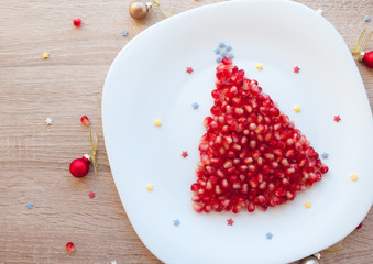 Pomegranate Christmas tree - healthy dessert or kids breakfast for Christmas, beautiful festive New Year background, blank space for text