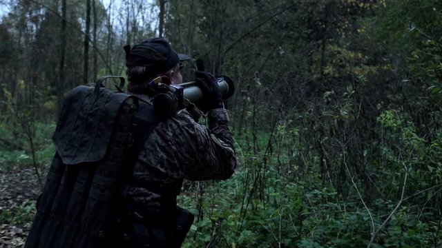 military in the forest shoots from a grenade launcher