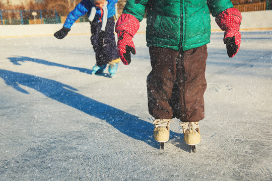 little girl and boy larning to skate, kids winter sport