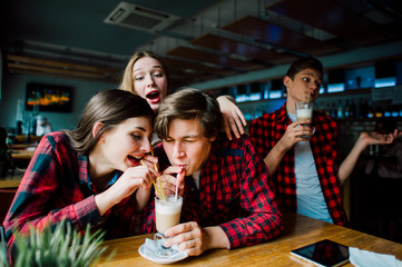 Group of young friends hanging out at a coffee shop. Young men and women meeting in a cafe having...