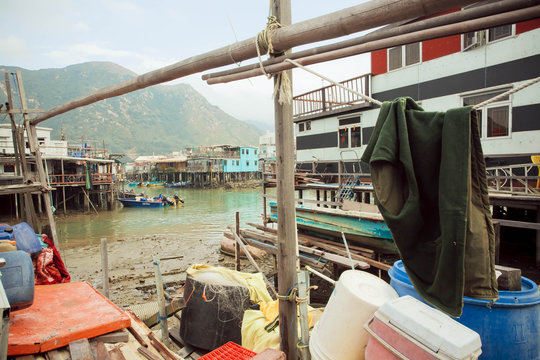 Rusty metal buildings of fishermen with riverboats of fishing village