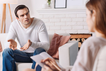 Fototapeta premium Emotional distressed man talking with psychologist