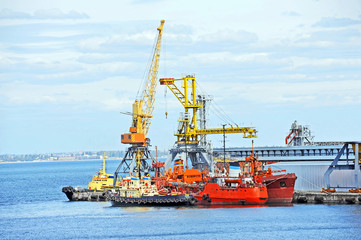 Fototapeta premium Bunker ship and tugboat under port crane, Odessa, Ukraine