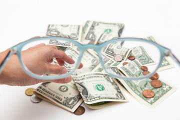 diverse currency through glasses, focused and blurry money on white backgrounds