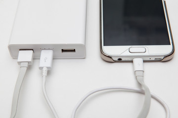 charging smart phone with portable battery on white backgrounds
