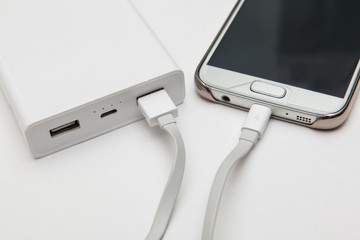 charging smart phone with portable battery on white backgrounds