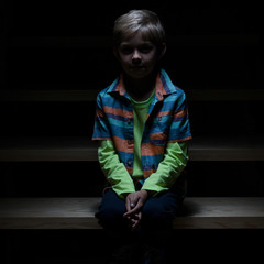 View of lonely boy sitting on staircase