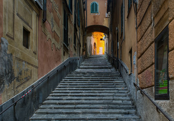 ascending stone stairs along the street Salita Di Negro with a small archway in Genoa, Italy