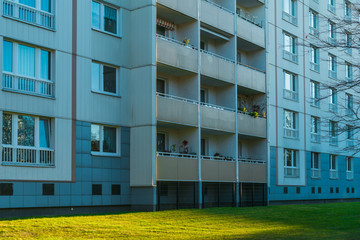 square angle balcony of old plattenbau building with green grass in the foreground