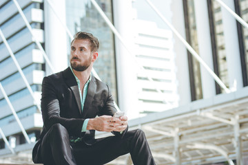 Smart businessman using smartphone at outdoor of the office buil