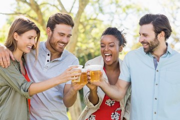 Couple toasting a glasses of beer in park