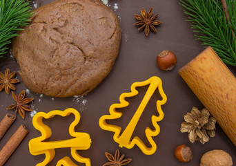 Christmas baking gingerbread, background: dough, flour and cookie cutters.