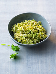 Pasta mixed with coriander pesto in a bowl