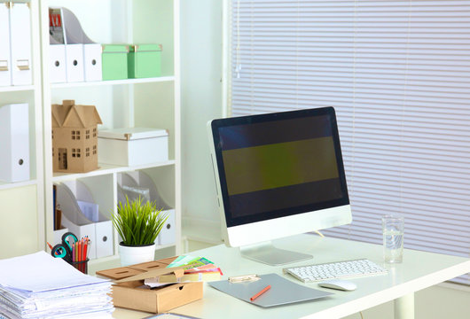 Designer working desk with a computer and paperwork