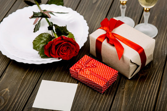 Little present boxes with red ribbons lie before white plate wit