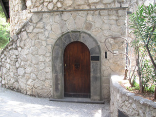 Circle head Wooden Door in Stone Wall in Daytime