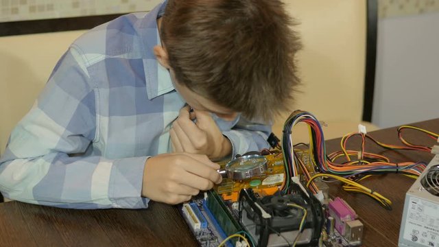 Teenager studying computer device. Adds RAM.