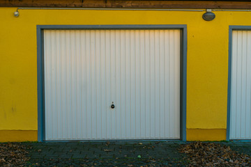 garage with yellow facade and white door