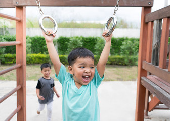 Asian boy playing on playground.