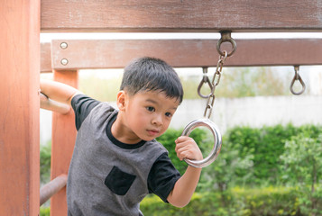 Asian boy playing on playground.