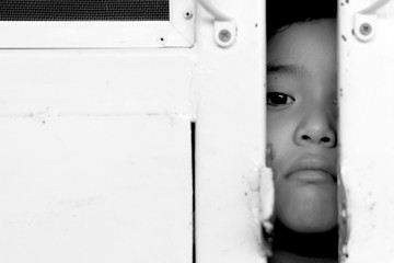 Kid with metal fence, feeling no freedom, black and white photog