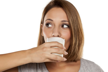 Young beautiful woman drinking milk from a glass
