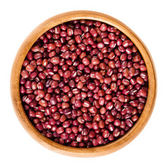 Red adzuki beans in wooden bowl, also called azuki, aduki or Red Mung Bean. Dried small beans of Vigna angularis. Isolated macro food photo close up from above on white background.