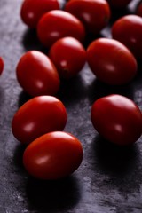Several cherry tomatoes on black board