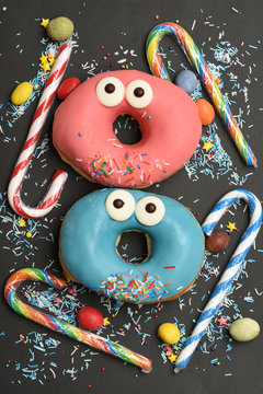 Funny glazed donuts on black background