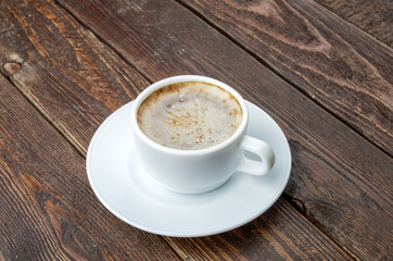 Coffee with foam on dark wood table