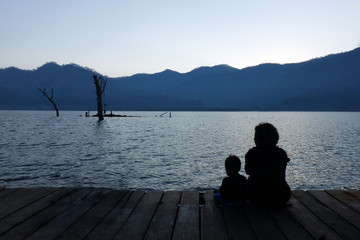 Silhouette mother and child watching the natural scenery.copy space