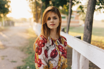Naklejka premium Young woman walking in the park in the rays 