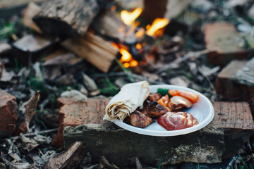  outdoor recreation, bonfire, shish kebab, pita bread, ketchup, vegetables