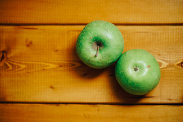 two green apples on a wooden background