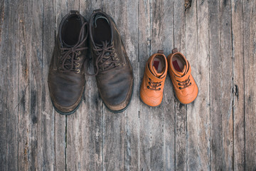 Daddy's boots and baby's shoes, fathers day concept.