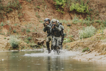 Military team crossing the river under fire