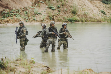 Military team crossing the river under fire